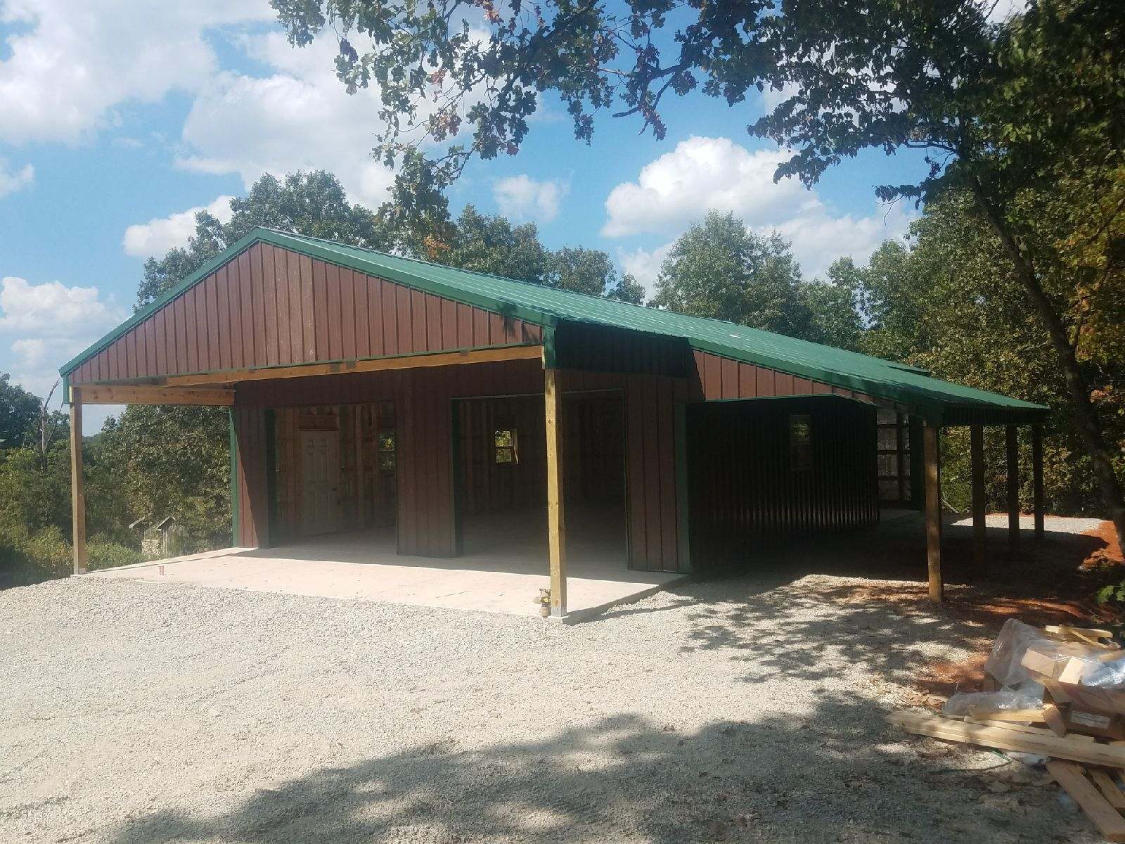 Pole barn with a green roof and open lean-to